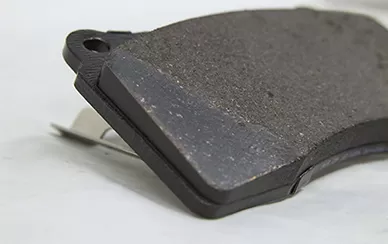 Why do garages chamfer the brake pads when installing new brake pad on old brake disc?